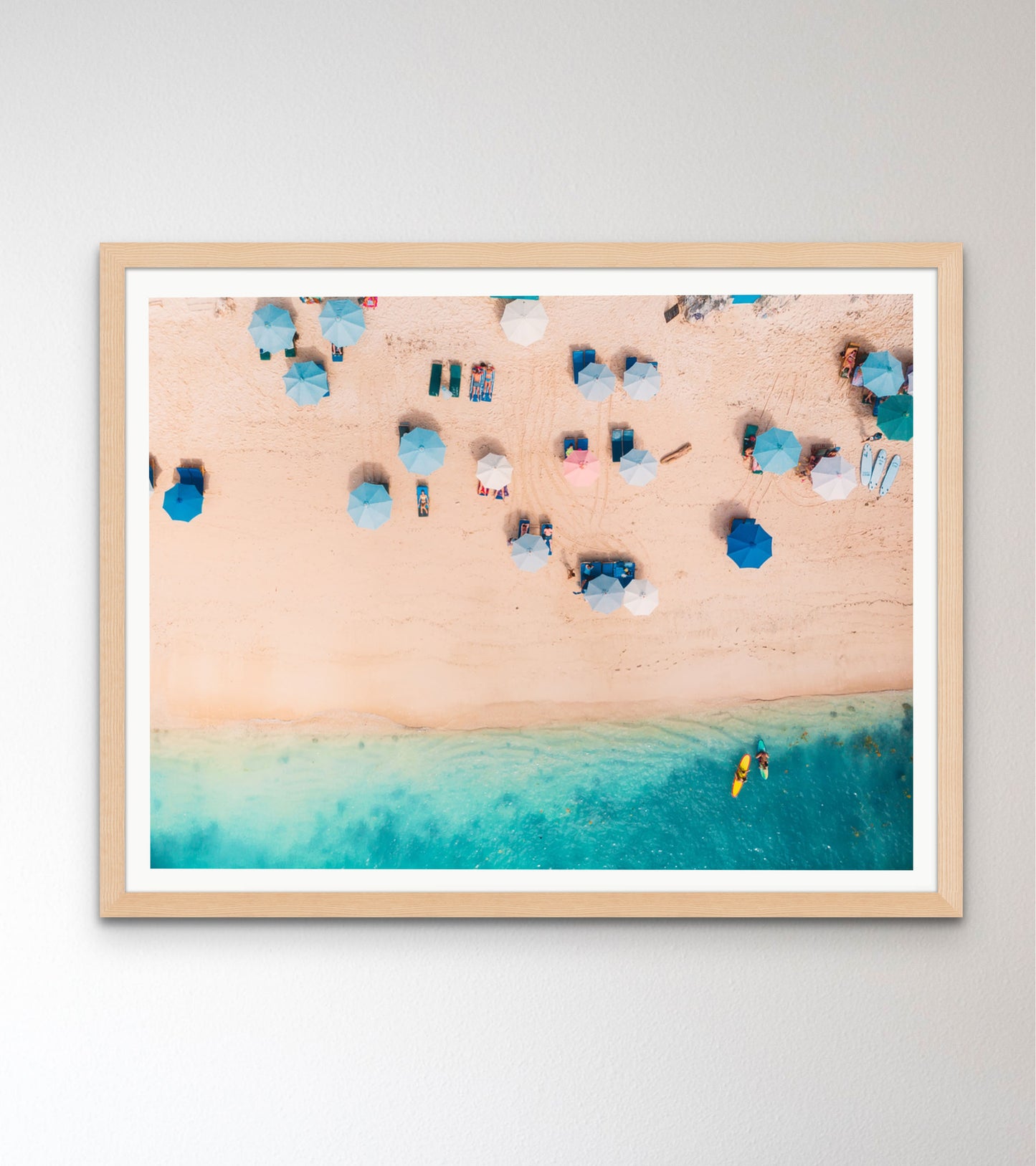 Top view of sandy beach with turquoise sea water and colorful blue umbrellas, aerial drone shot